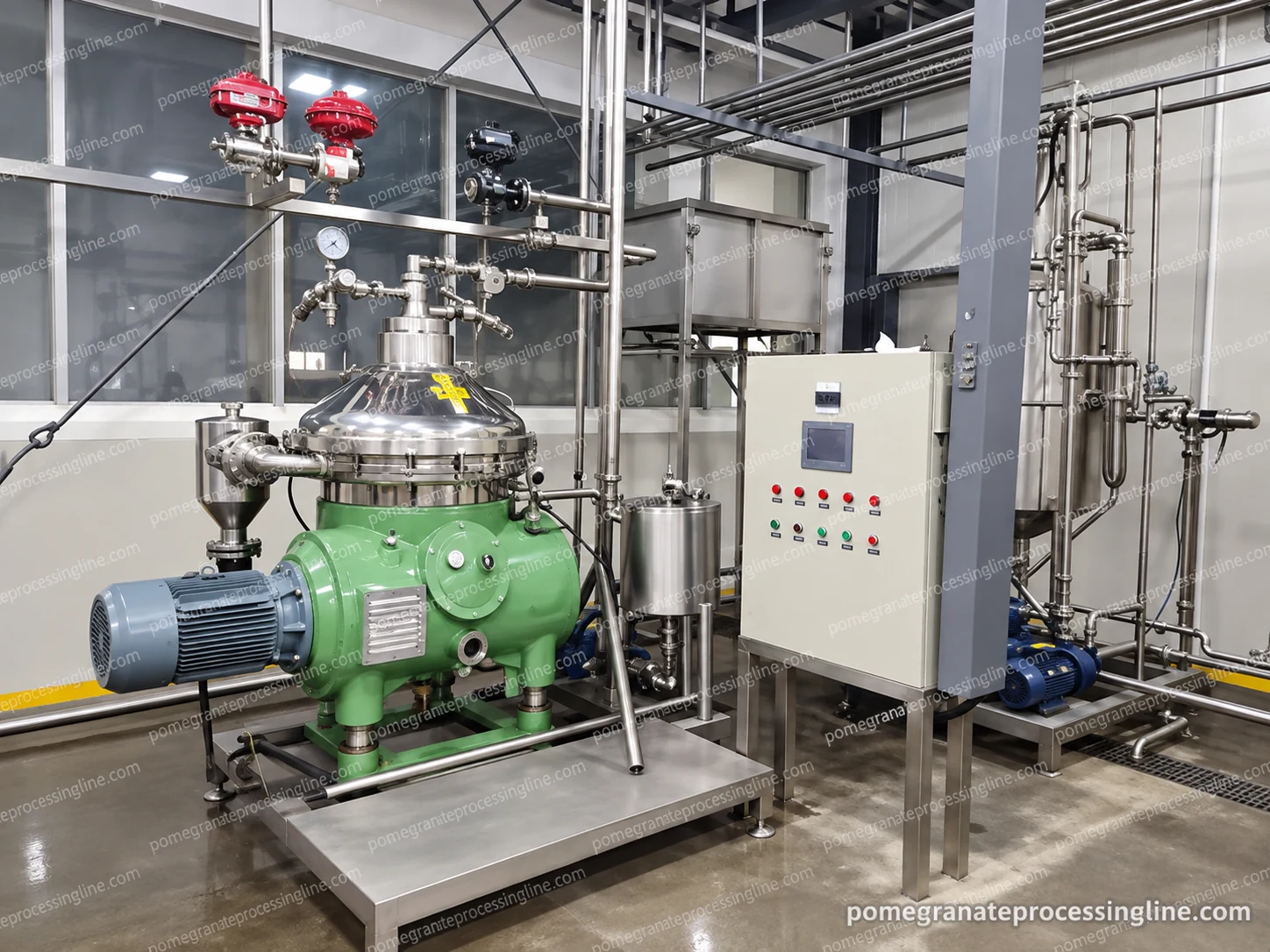 Installed separator with a stainless bowl housing, green drive body, outlet pipes and adjacent control cabinet